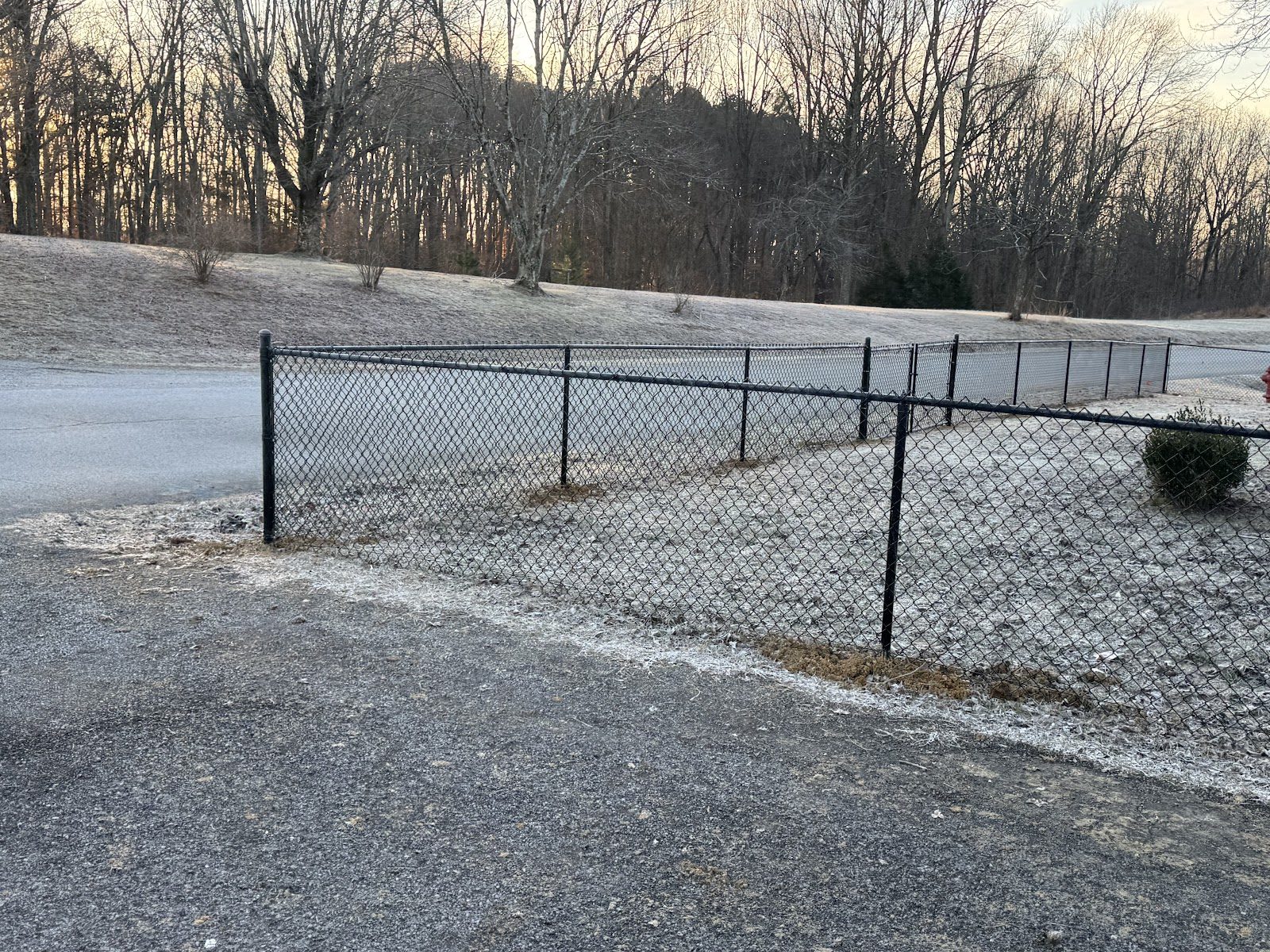 Black chain link fence along a gravel yard